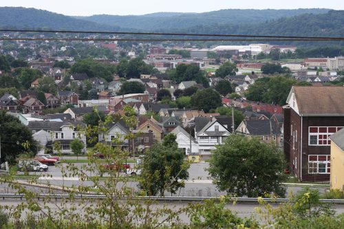 Aerial view of a small town nestled among wooded hills