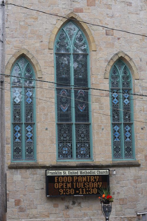 Stained glass windows on the stone facade of Franklin St. United Methodist Church